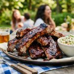 A plate of grilled ribs at an outdoor gathering.