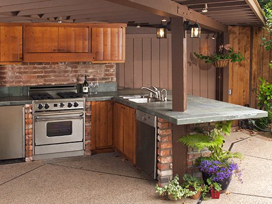 outdoor kitchen with wood cabinet accents