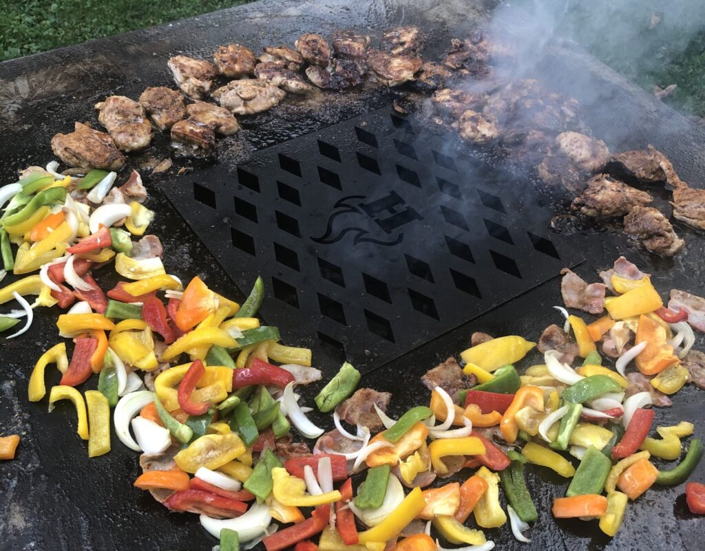 Chopped vegetables and chicken grilling on a Hancock Grill