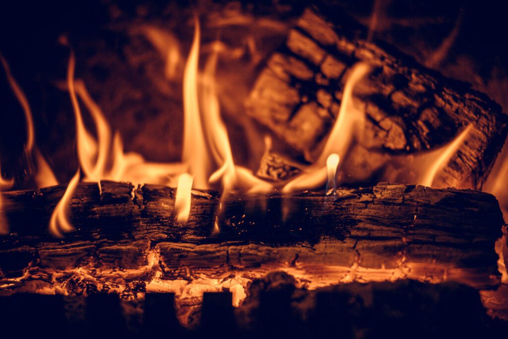 A log burns in a wood-burning fireplace.