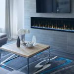 A beautiful electric fireplace in the wall in a grayscale livingroom.
