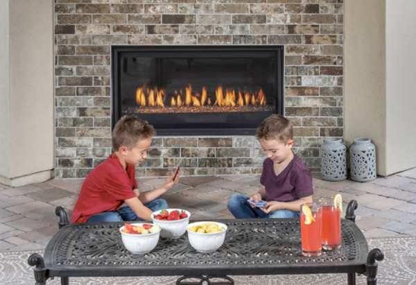 An image of two smiling children eating snacks and playing in front of a Montigo fireplace.