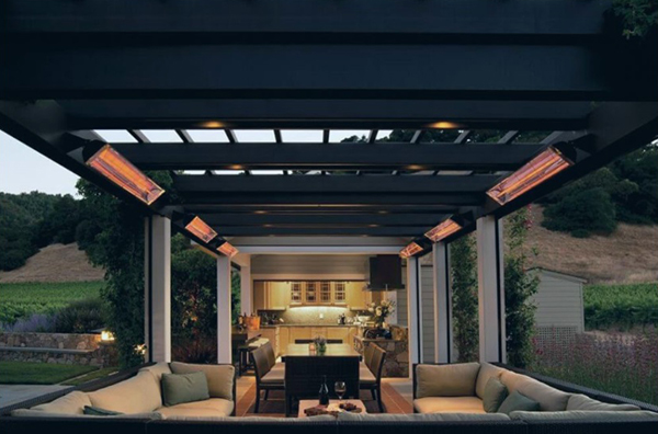 An image of several outdoor electric heaters hanging over modern-looking black furniture with tan cushions.