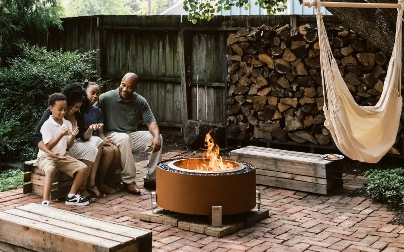 a family sitting by a Breeo firepit