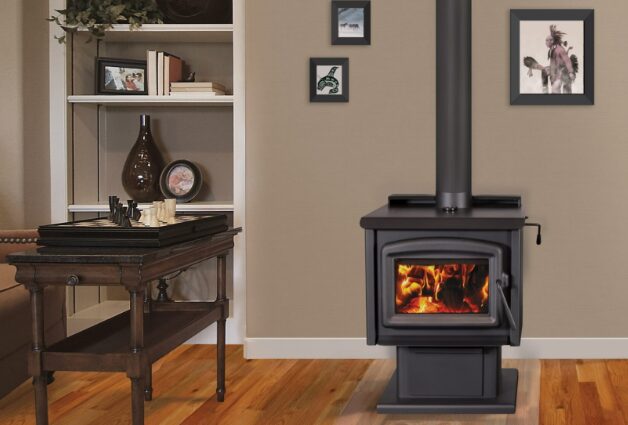 a wood stove in a comfortable family room with a small wooden table on the left
