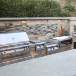 A backyard kitchen setup with a grill and other appliances.